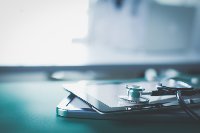 Medical equipment: blue stethoscope and tablet on white background. Medical equipment