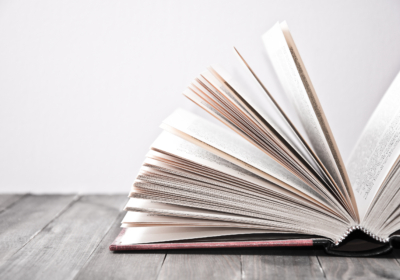 Open book on wooden table.