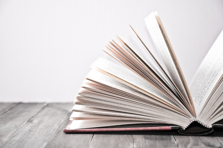 Open book on wooden table.